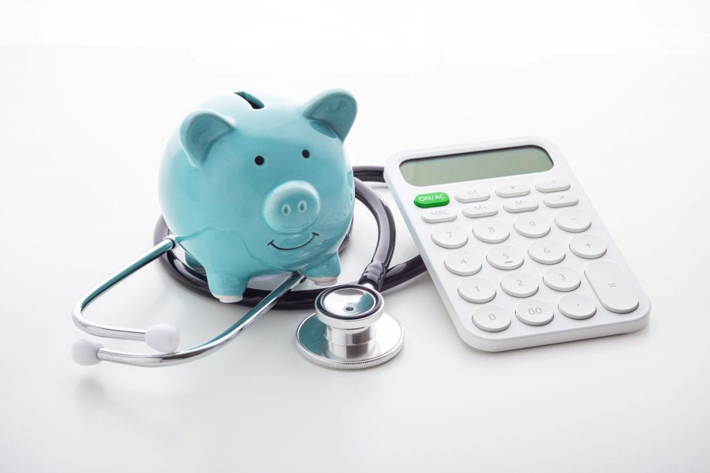 Piggy bank with stethoscope and calculator