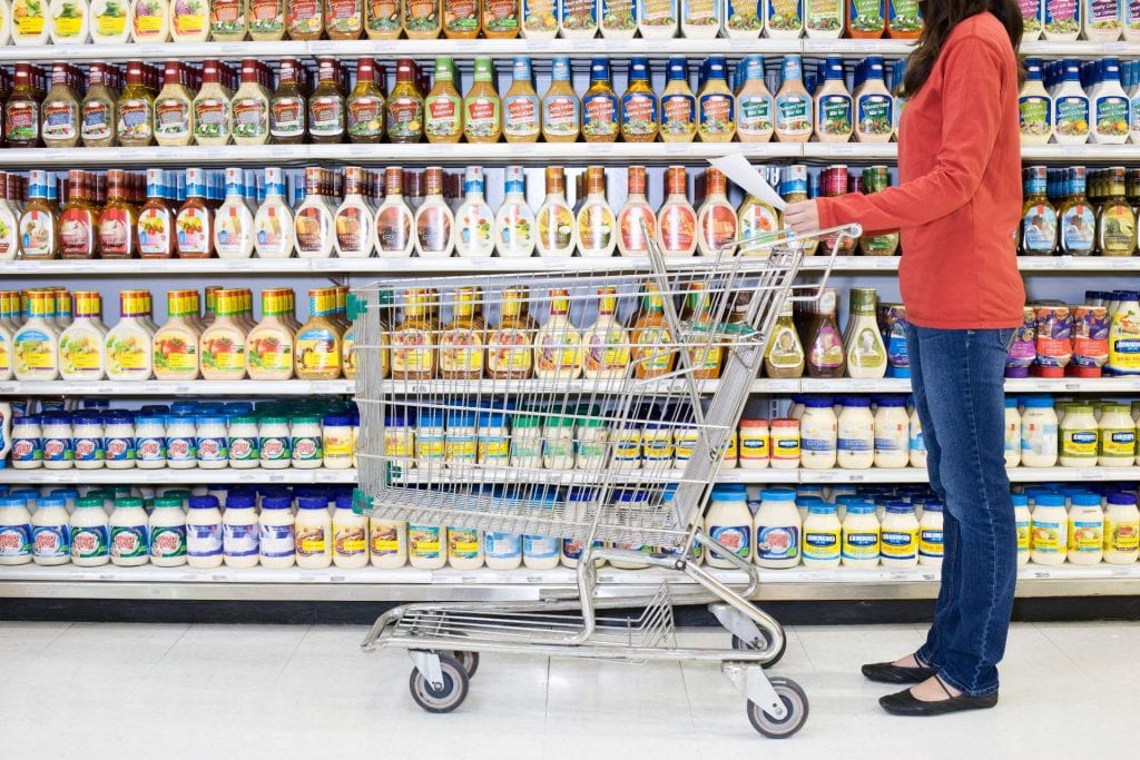 Shopper checking list in supermarket aisle